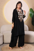 Woman wearing a black outfit with intricate white and gold embroidery 