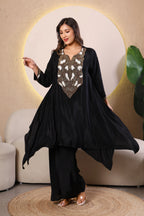 Woman wearing a black outfit with intricate white and gold embroidery 