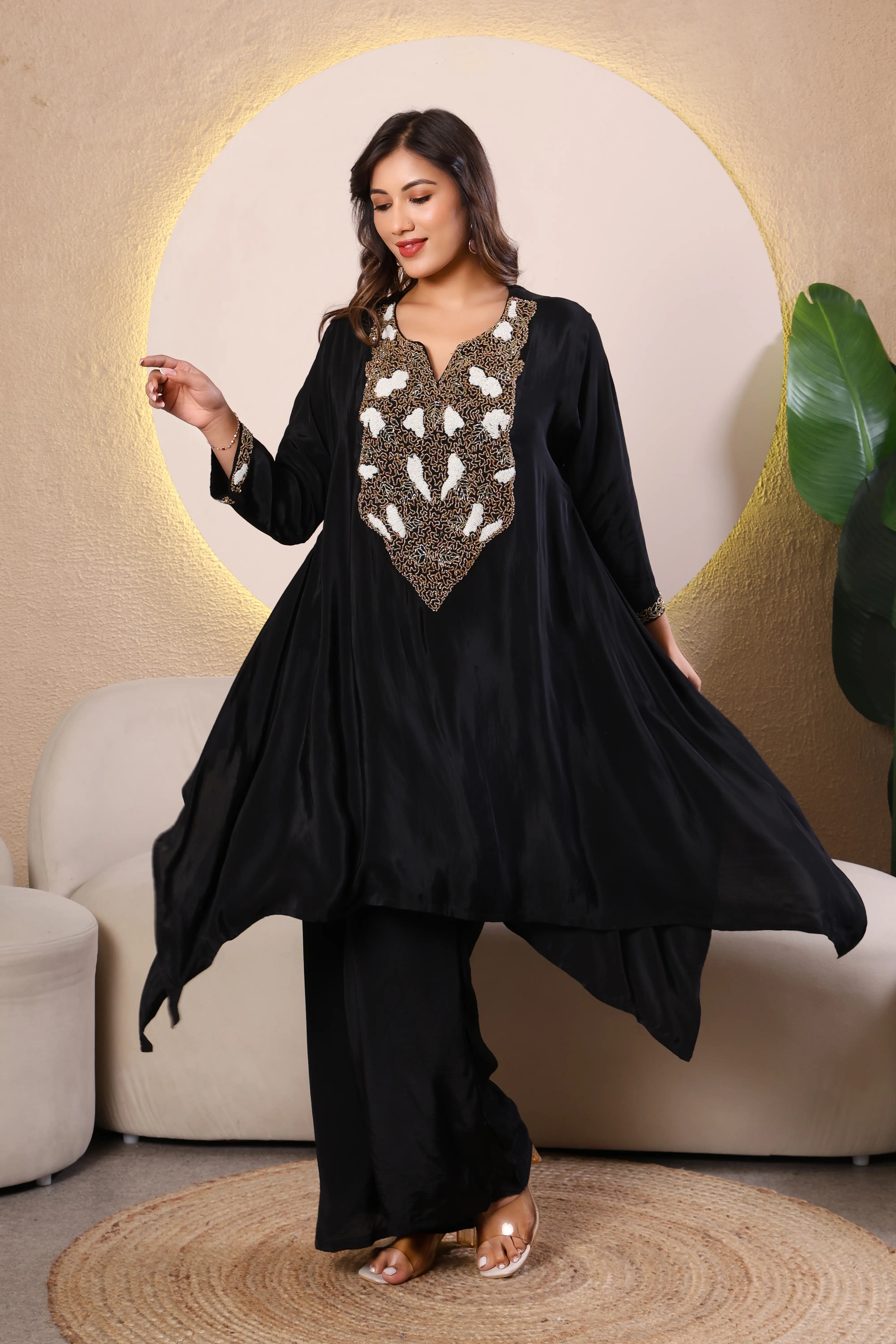 Woman wearing a black outfit with intricate white and gold embroidery 