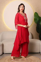 Woman in a red traditional outfit ith intricate cutdana and thread embroidery at the neckline, paired with a shantoon slip and crepe bell bottoms, 