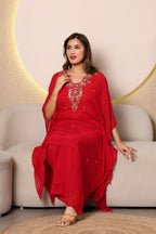 Woman in a red traditional outfit ith intricate cutdana and thread embroidery at the neckline, paired with a shantoon slip and crepe bell bottoms, 
