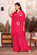 Woman wearing a bright pink outfit with gold patterns.