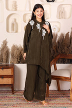 Woman wearing a dark brown traditional outfit with floral embroidery 