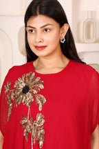 Woman wearing a red outfit with floral embroidery
