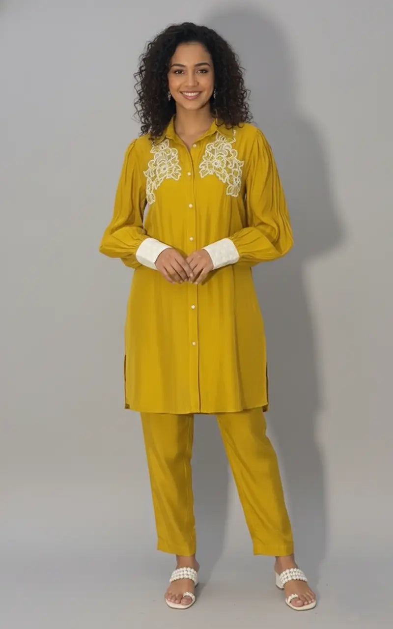 Woman wearing a yellow traditional outfit with white lace details on a gray background