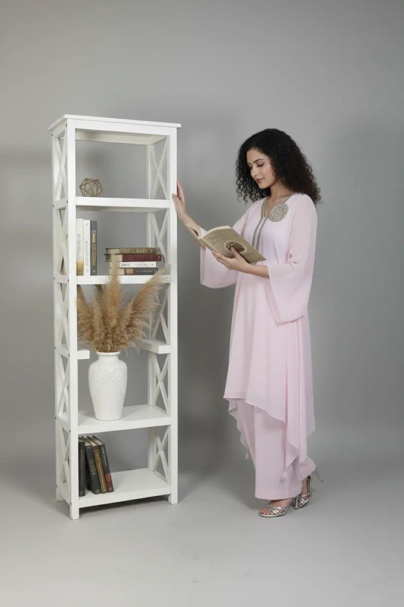 Woman wearing A soft pink pure georgette kurti set featuring fine cutdana and stone work, paired with crepe bell-bottom pants.