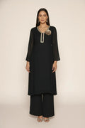 Woman wearing a  black pure georgette kurti set, detailed with shimmering cutdana and stone work. Paired with soft crepe bell-bottom pants and a shantoon lining,