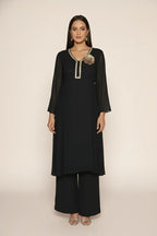 Woman wearing a  black pure georgette kurti set, detailed with shimmering cutdana and stone work. Paired with soft crepe bell-bottom pants and a shantoon lining,