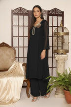 Woman wearing a  black pure georgette kurti set, detailed with shimmering cutdana and stone work. Paired with soft crepe bell-bottom pants and a shantoon lining,