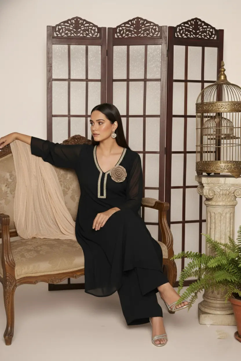 Woman wearing a  black pure georgette kurti set, detailed with shimmering cutdana and stone work. Paired with soft crepe bell-bottom pants and a shantoon lining,