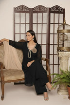 Woman wearing a  black pure georgette kurti set, detailed with shimmering cutdana and stone work. Paired with soft crepe bell-bottom pants and a shantoon lining,