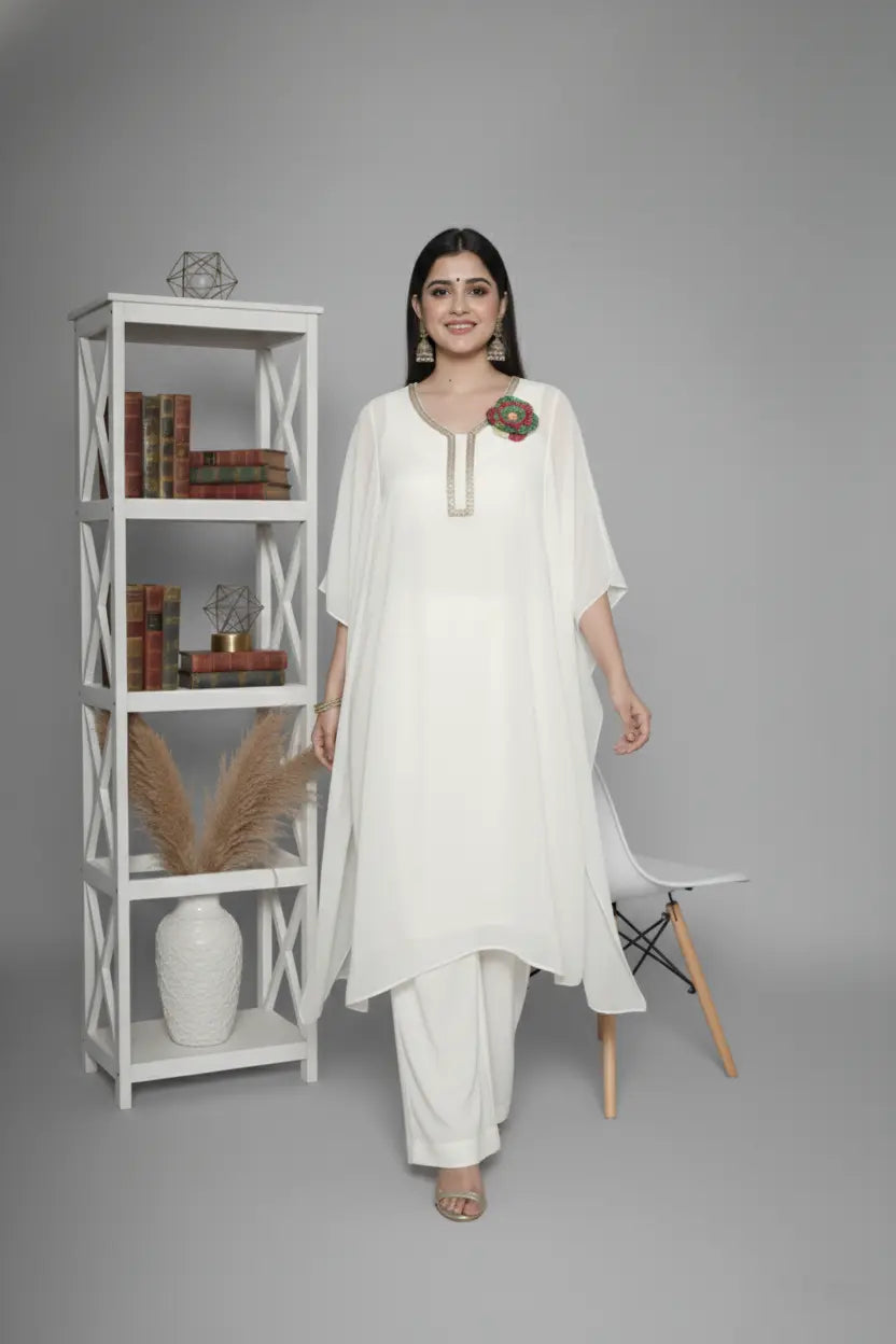 Woman wearing ivory Reagan-style kaftan co-ord set, crafted in pure georgette with vibrant thread floral applique and delicate cutdana accents. Paired with crepe bell-bottom pants and soft shantoon lining for a luxurious festive look.