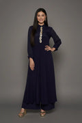 Woman wearing a sophisticated navy blue chinnon chiffon co-ord set featuring a shirt-style kurti with elegant box pleats and hand-crafted zardozi embroidery adorned with pearls and sequins. Paired with soft crepe bell-bottom pants and shantoon lining,